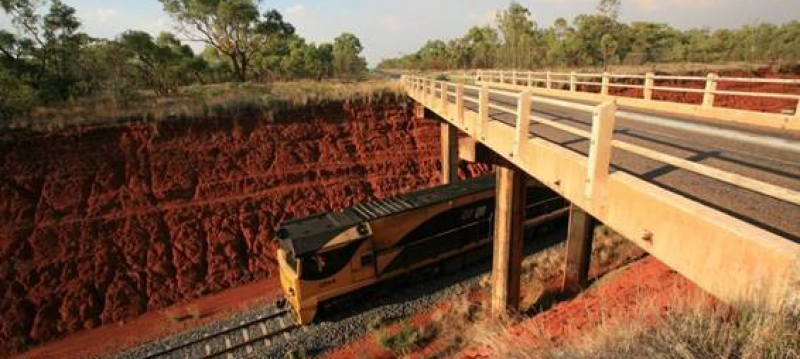 Train going underneath a bridge
