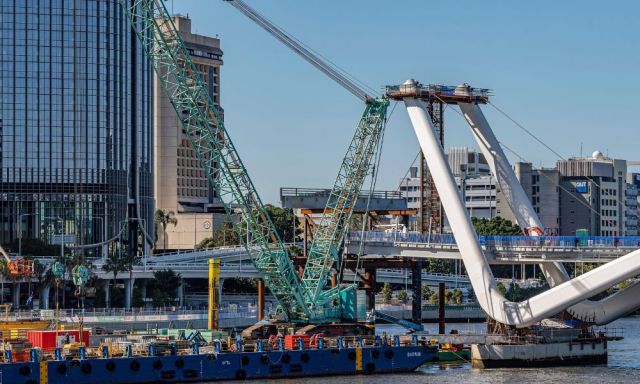 Construction images of the Neville Bonner Bridge with cranes and work boats