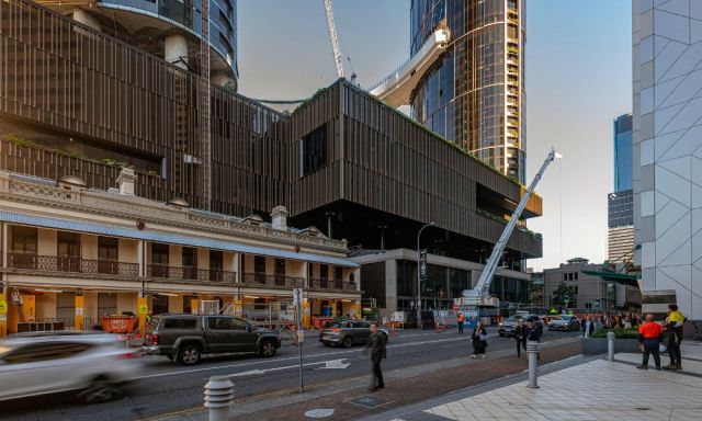 An almost complete Queens Wharf from thew view of George Street. There are cars driving past on the road.